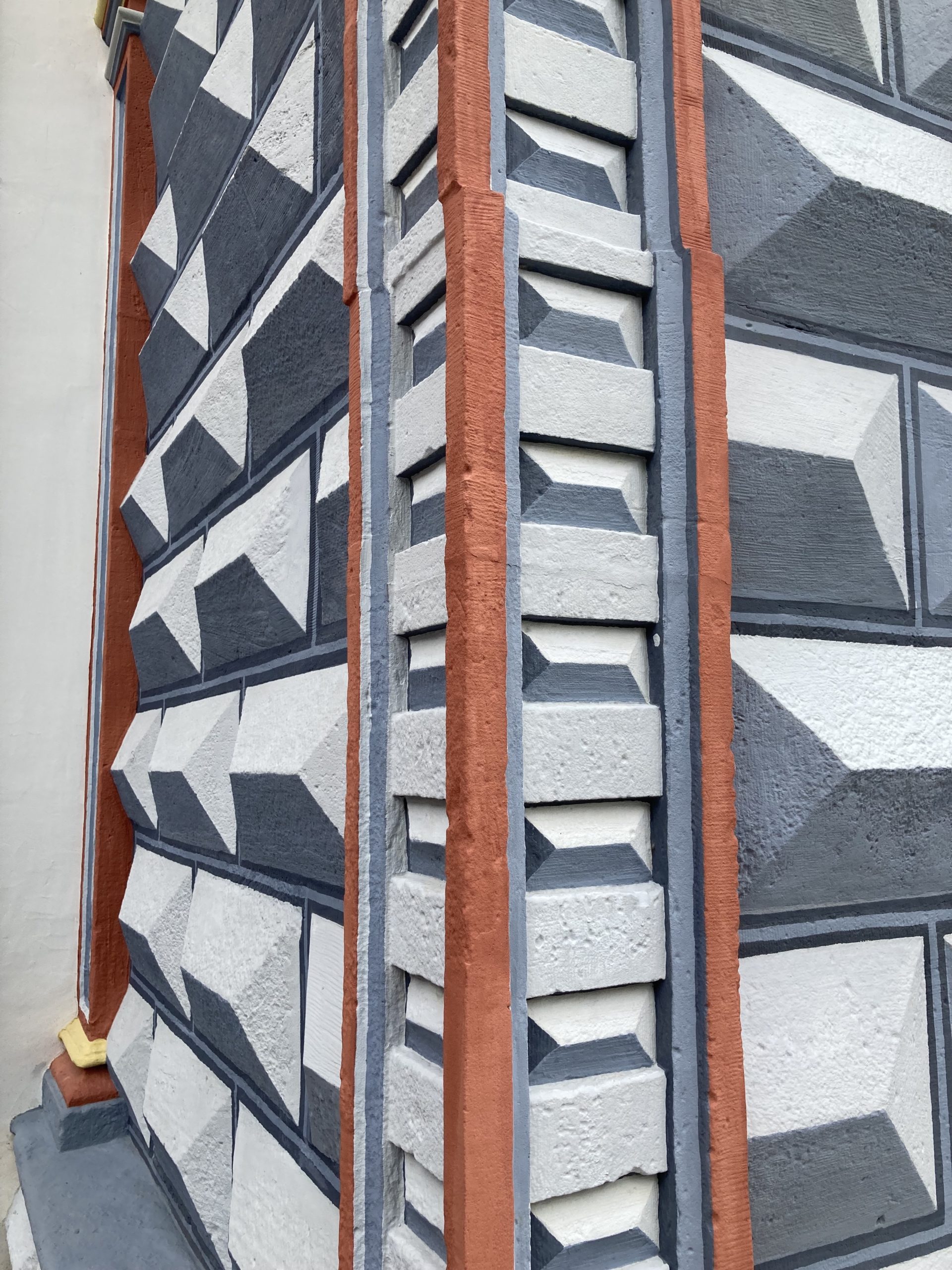 a detail from a wall showing what looks like trompe l'oeil painting but where the paint just brings out the architectural design more strongly